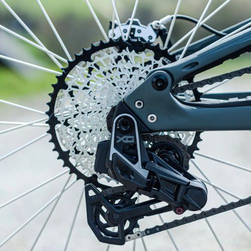 Gros plan sur la transmission VTT monoplateau avec dérailleur arrière SRAM XO Eagle AXS et cassette grand pignon sur roue arrière